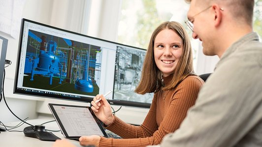 2 technische Produktdesigner schauen sich im Büro vor dem Computer an