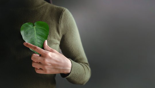 Frau mit Blatt in Herzform in der Hand